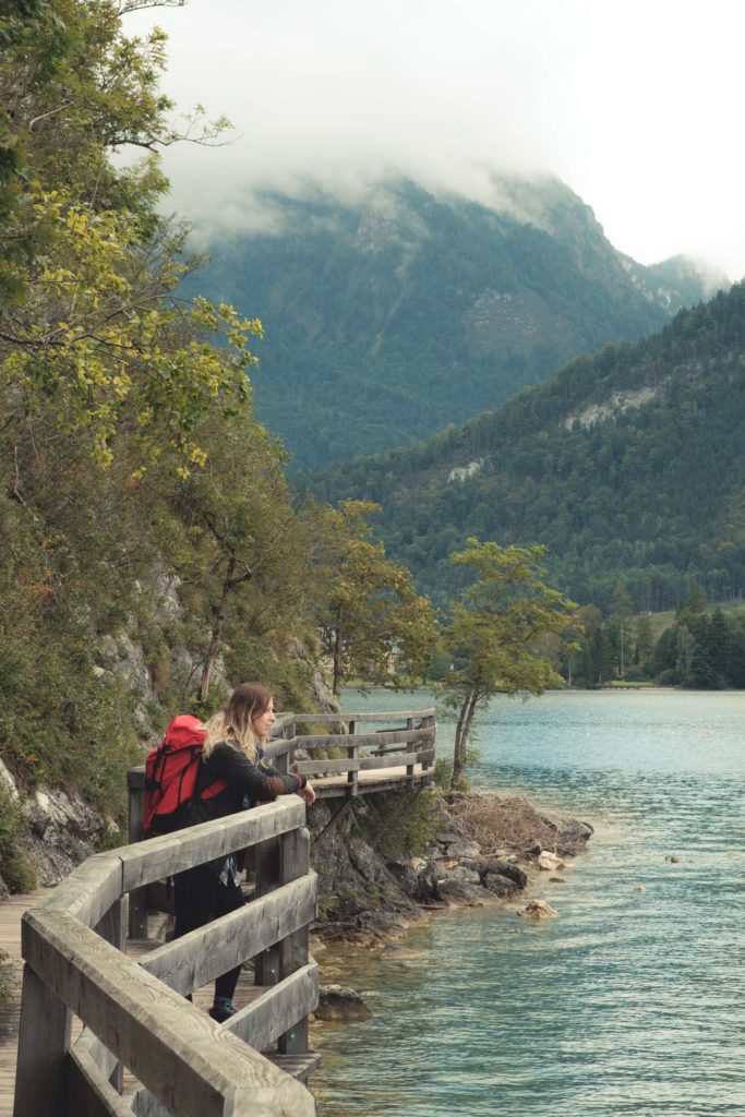 Caroline enjoying the view from the boardwalk to Strobl, with cloudy mountains surrounding the lake