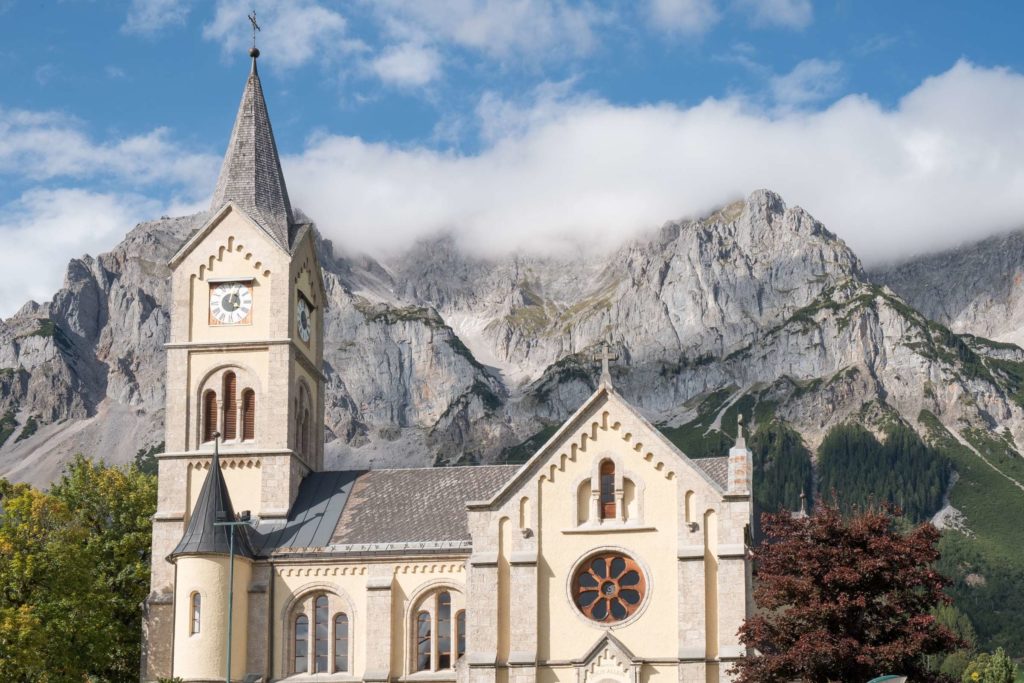 Protestant church in Ramsau am Dachstein with Dachstein mountain range towering in the back