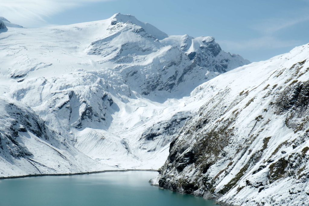 Mooserboden damn with turquoise water and snowy mountains