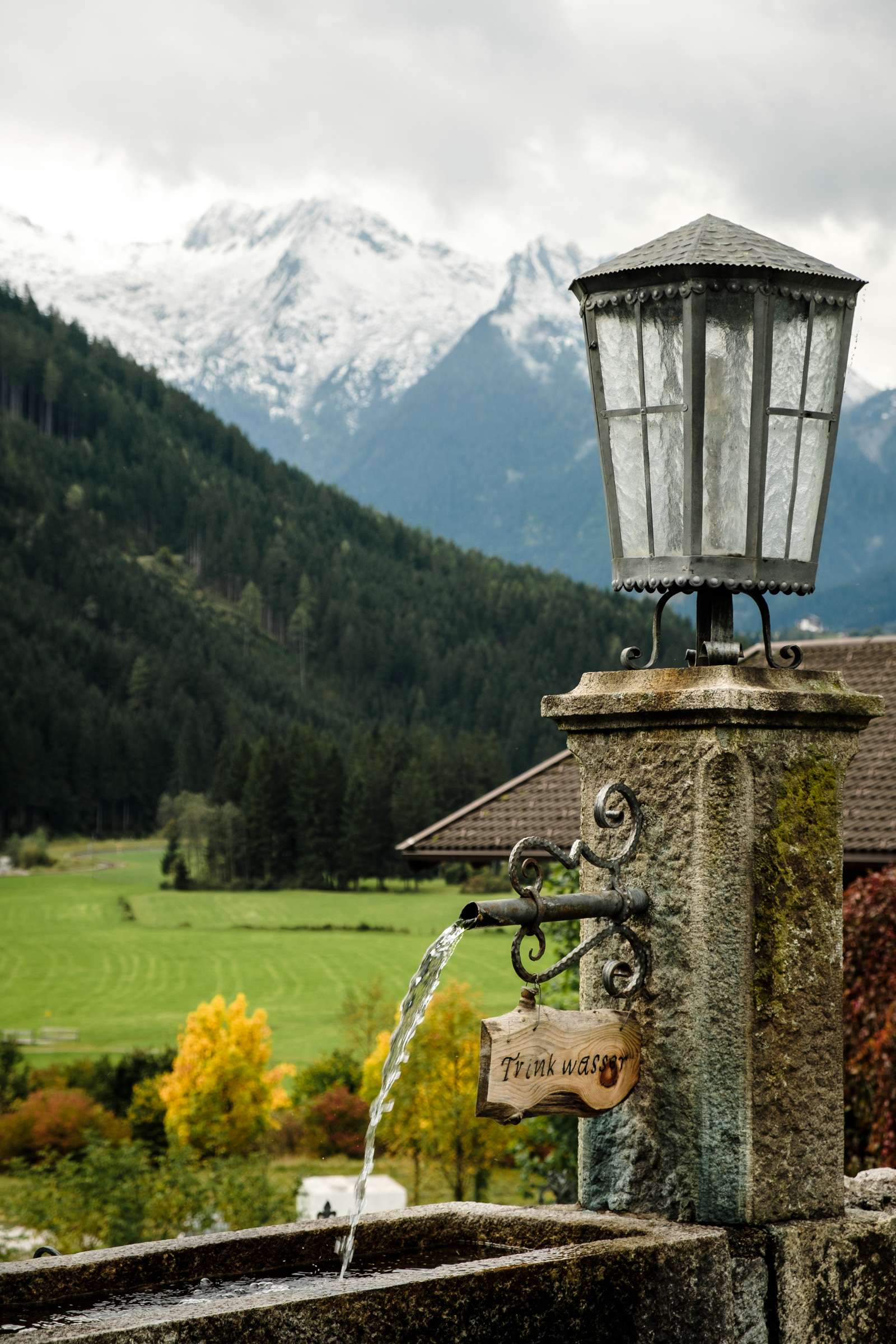 A beautiful stone water fountain with snowy peaks in the background