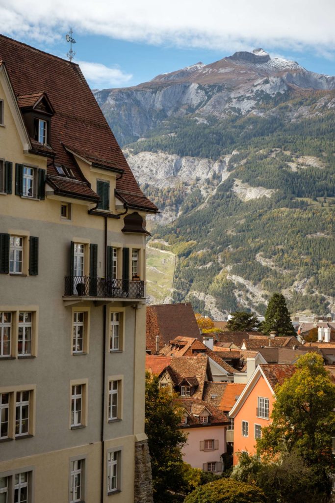 Close up shot of old town Chur with roofs and spires with mountain peak