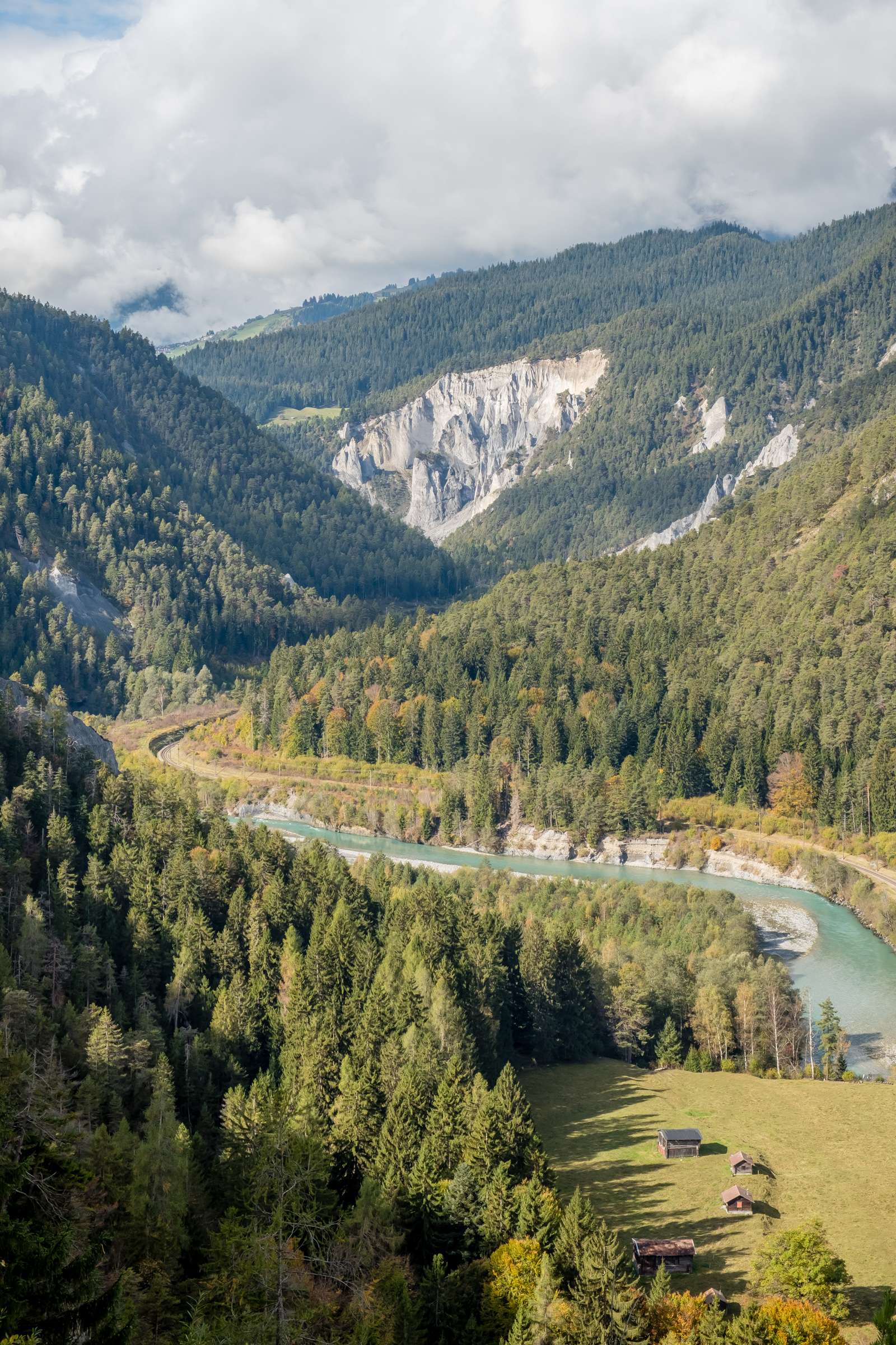 The Ruinaulta gorge with cute wooden cabins sitting next to the chalk coloured river. The grand canyon of Switzerland.