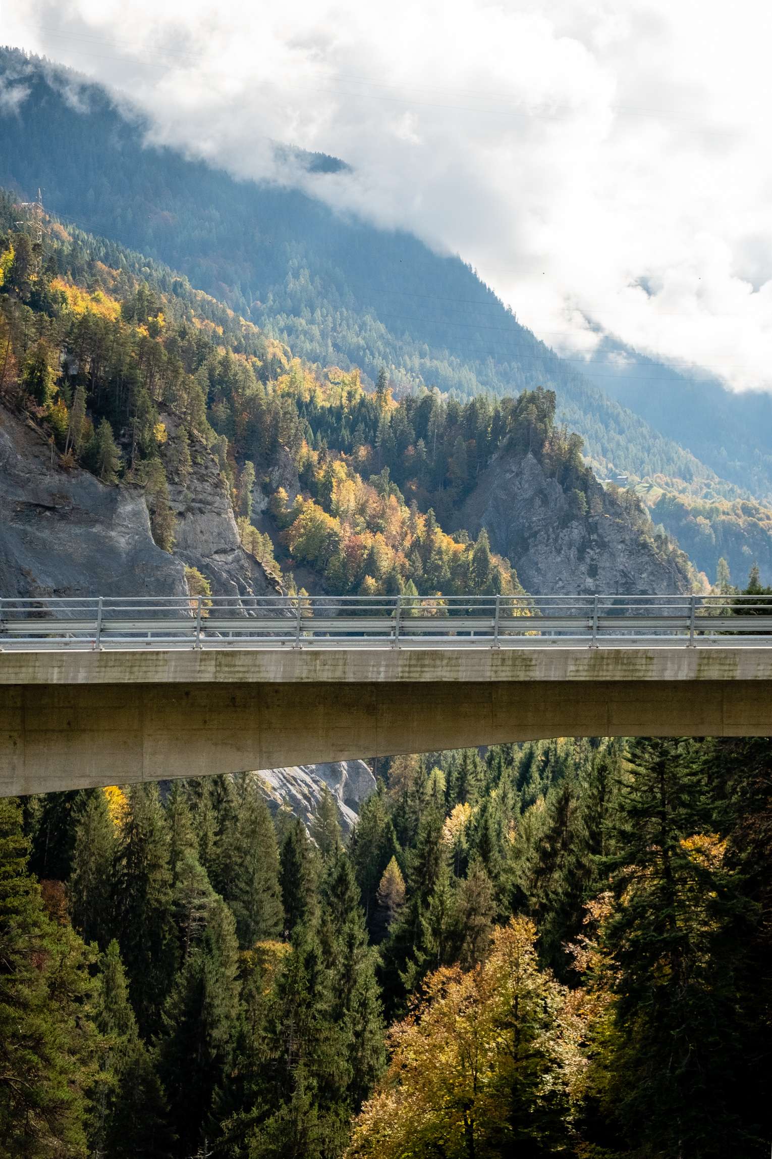 The new Versamer Tobelbrücke, shot from the old bridge, with a backdrop of mountains.