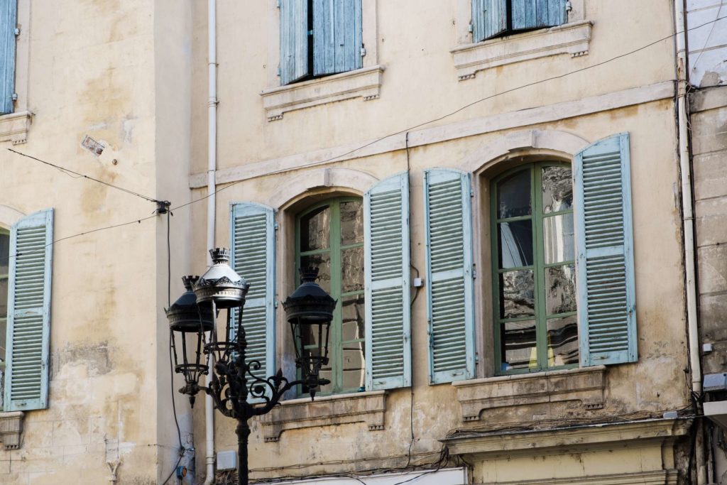 Window details with blue shutters and old gothic lamp