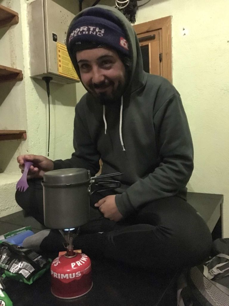 Aydin cooking dinner in the mountain hut