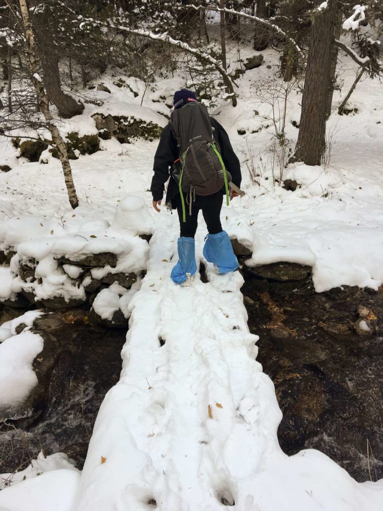 Aydin looking ridiculous wearing plastic bags over socks crossing a bridge