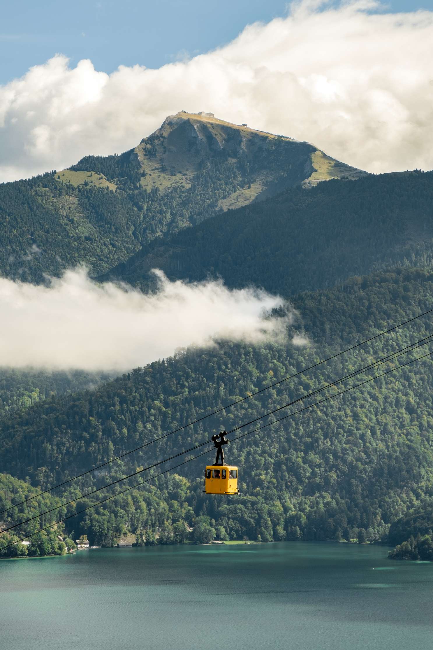 A cablecar engulfed by Schafberg as a backdrop