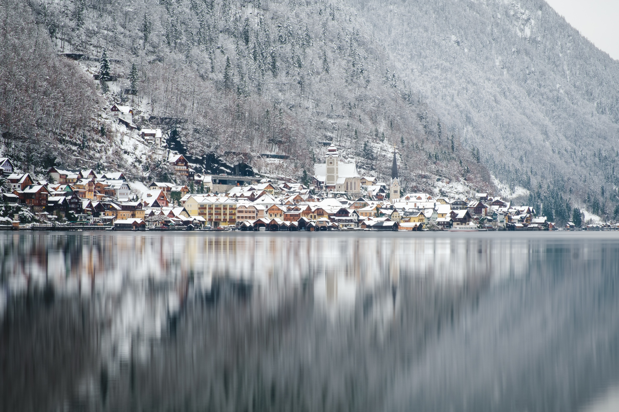 Hallstatt in the snow and its reflections on the lake