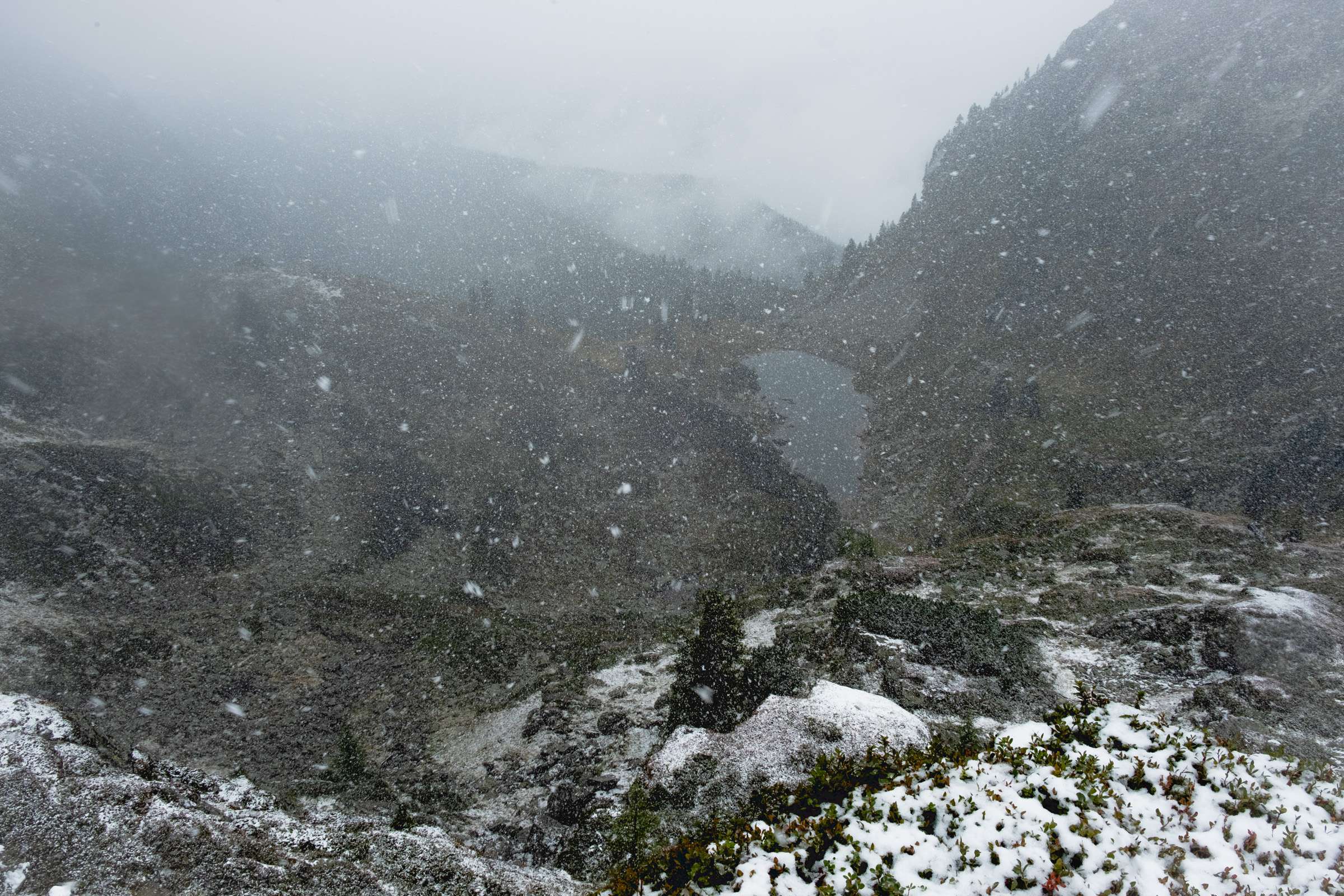 Snow falling down with a view of Spiegelsee