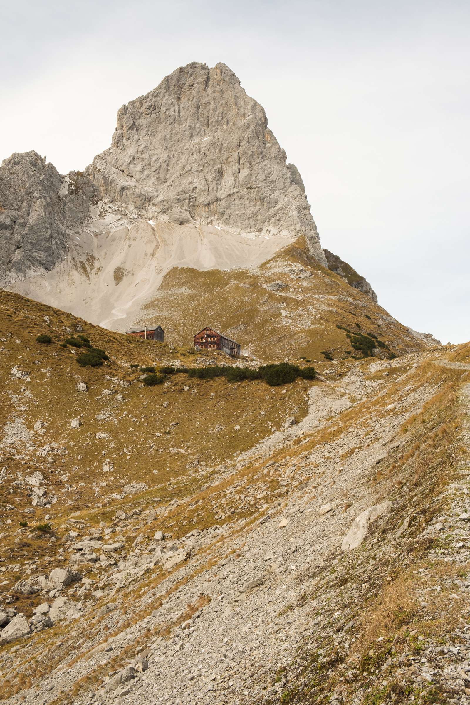 Looking up to Lamsenjochhütte on the descent with a high peak towering over