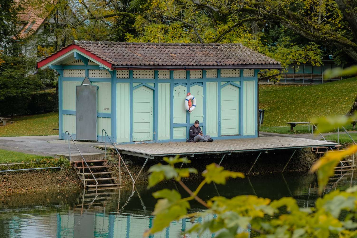 A teenager sitting in front of a vintage shed at Drei Weieren in St. Gallen