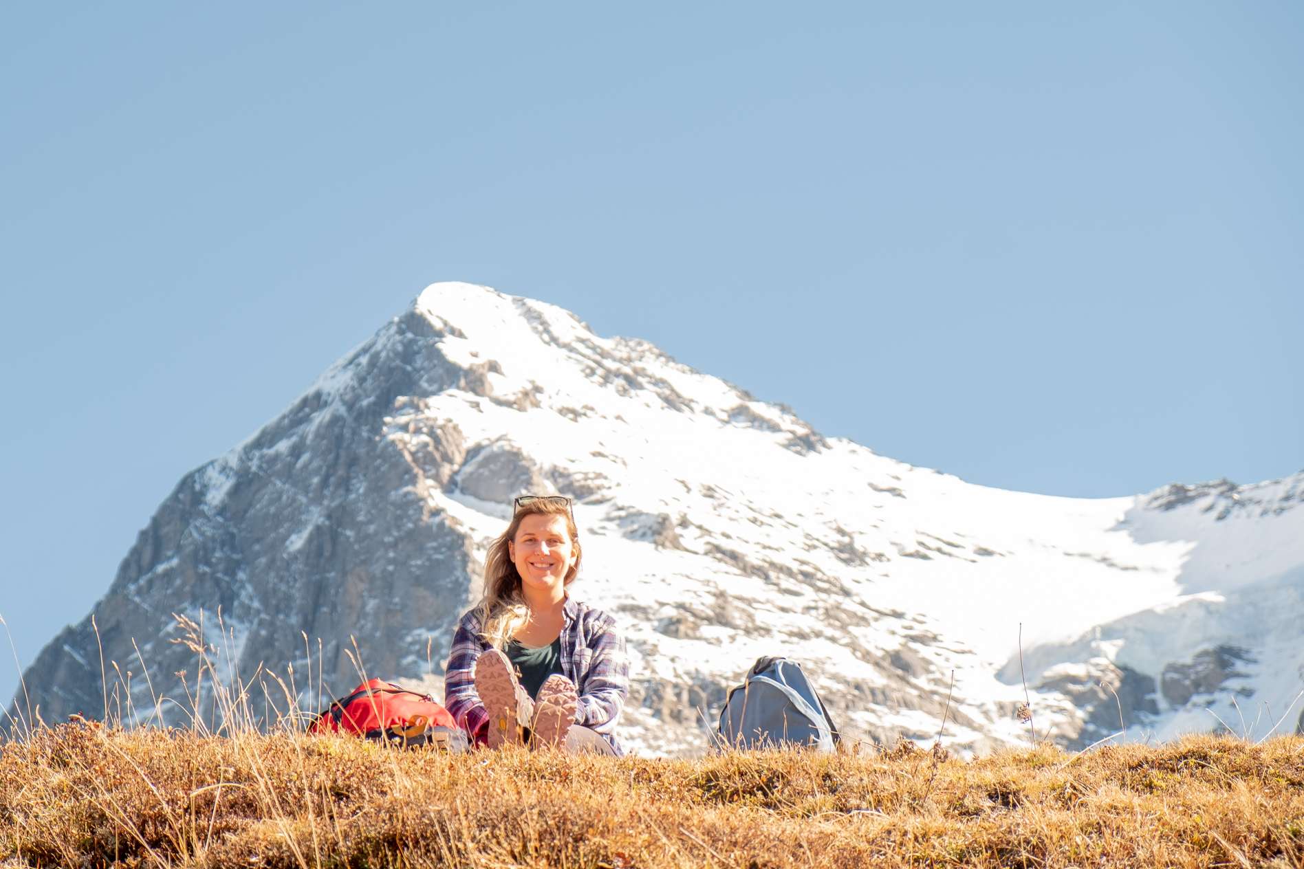 Caroline enjoying the sun below snowy peak