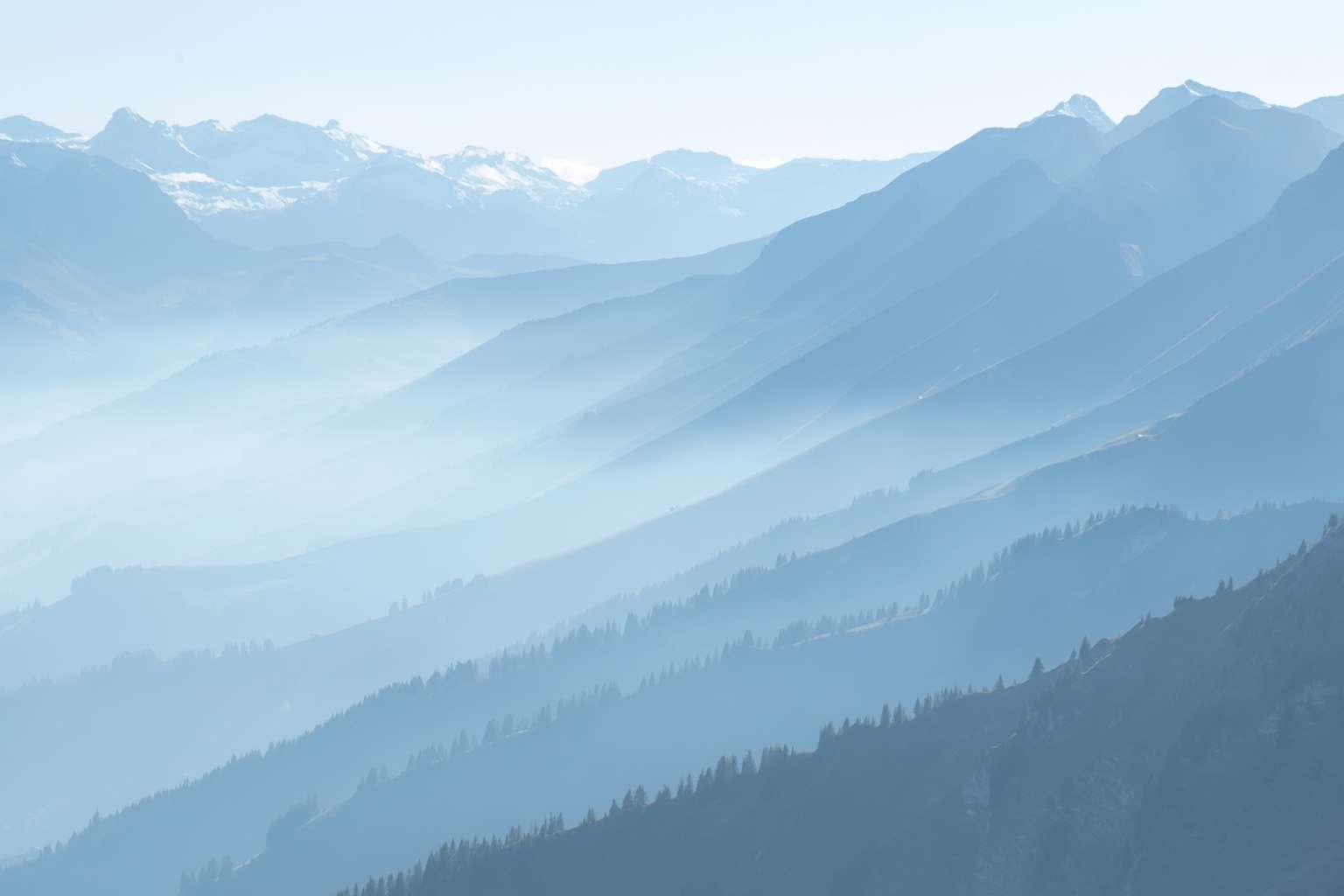 Close up hazy blue layered mountain slopes from Niesen