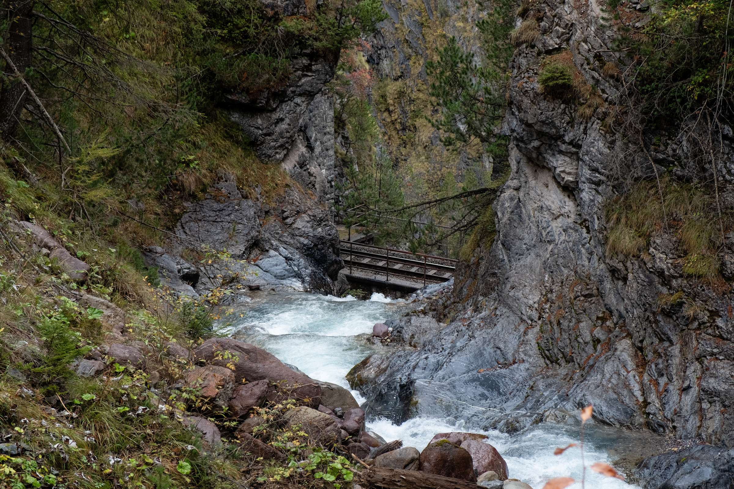 Train tracks passing over a waterfall on the Glacier Express