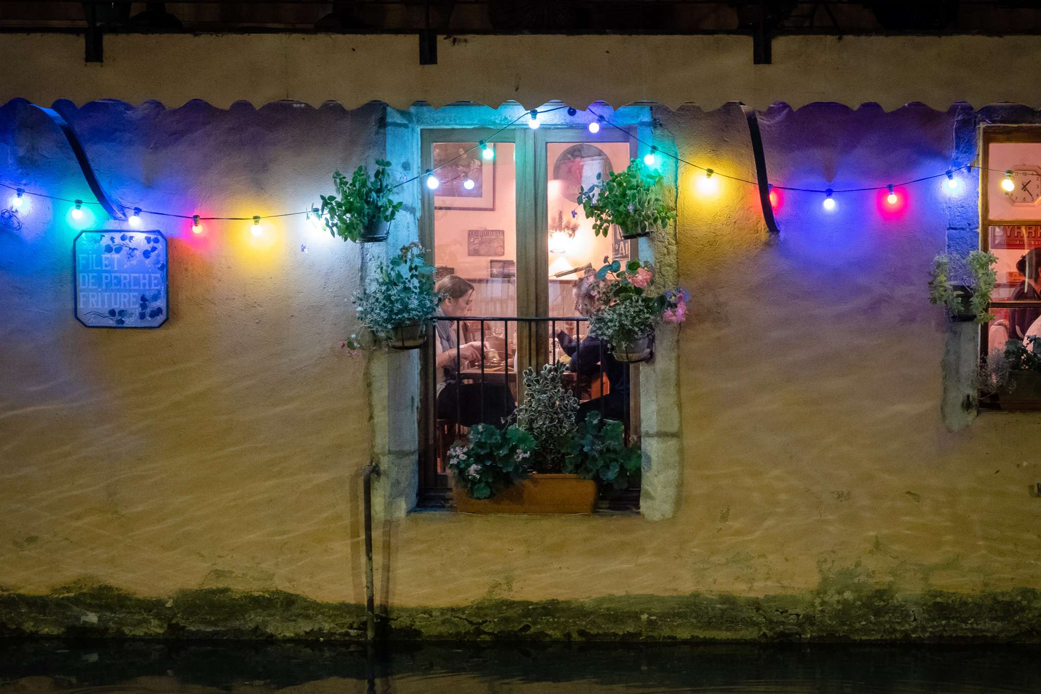 A couple eating dinner in a canal side restaurant