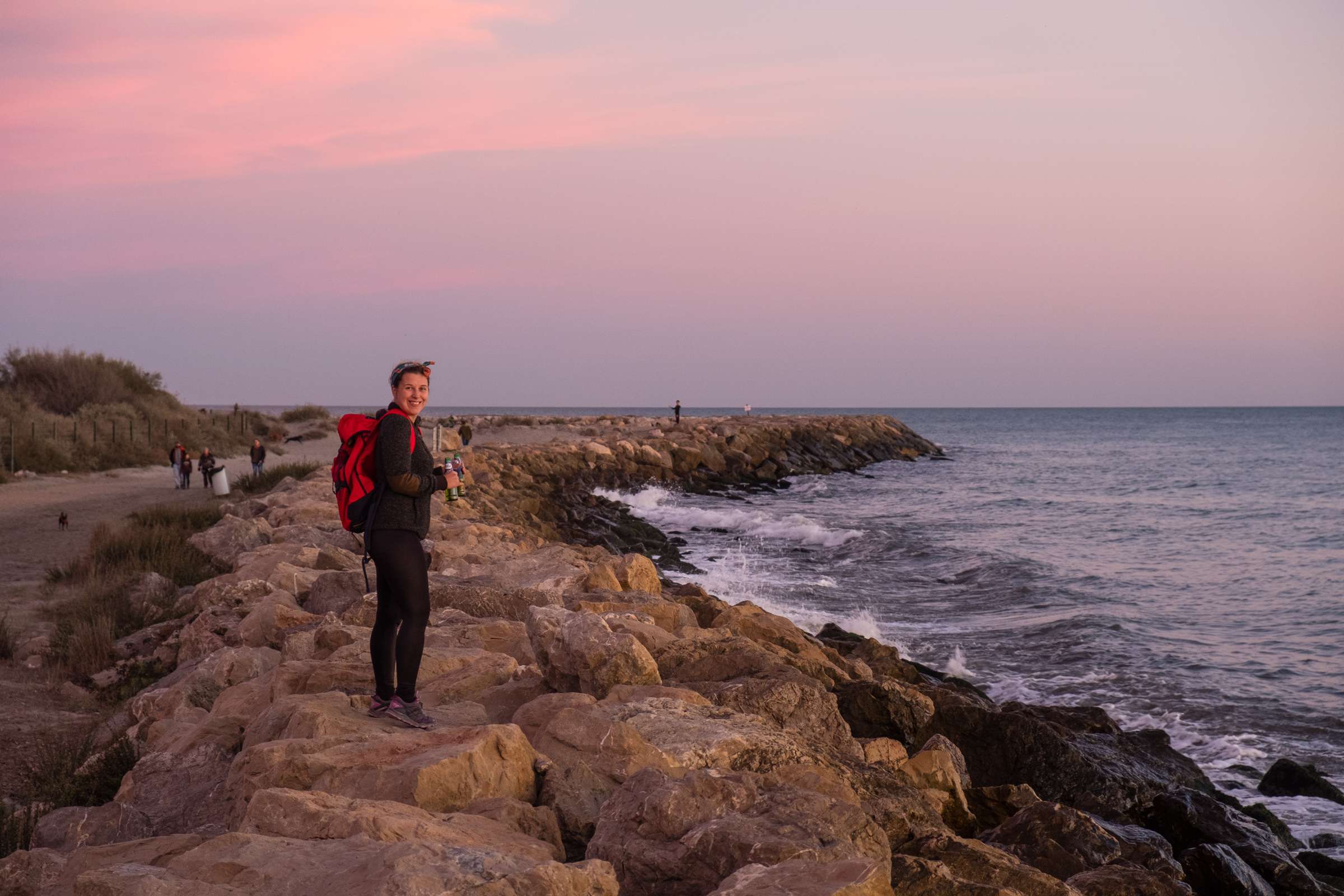 Caroline walking on the beach rocks with beers