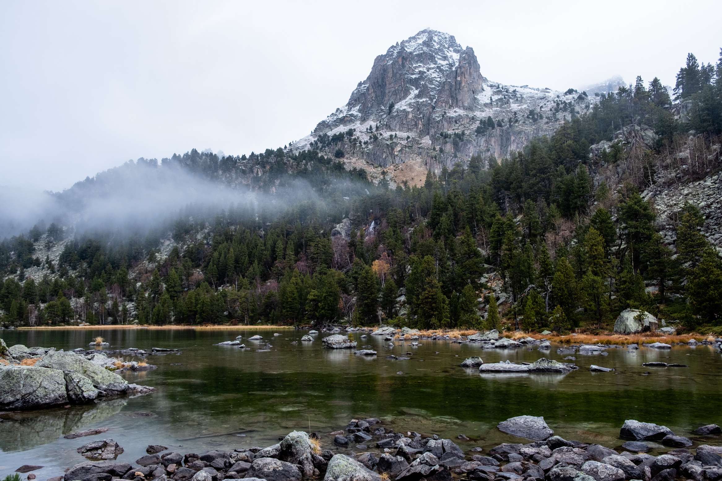 Fog hanging over lake Ratera in Aigüestortes i Estany of Saint Maurici national park