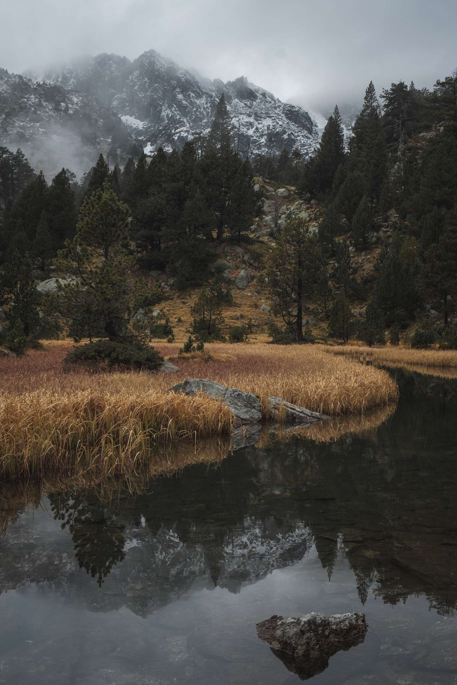 Still river reflecting mountains in Aigüestortes i Estany of Saint Maurici national park