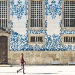 Man walking past side of Igreja do Carmo