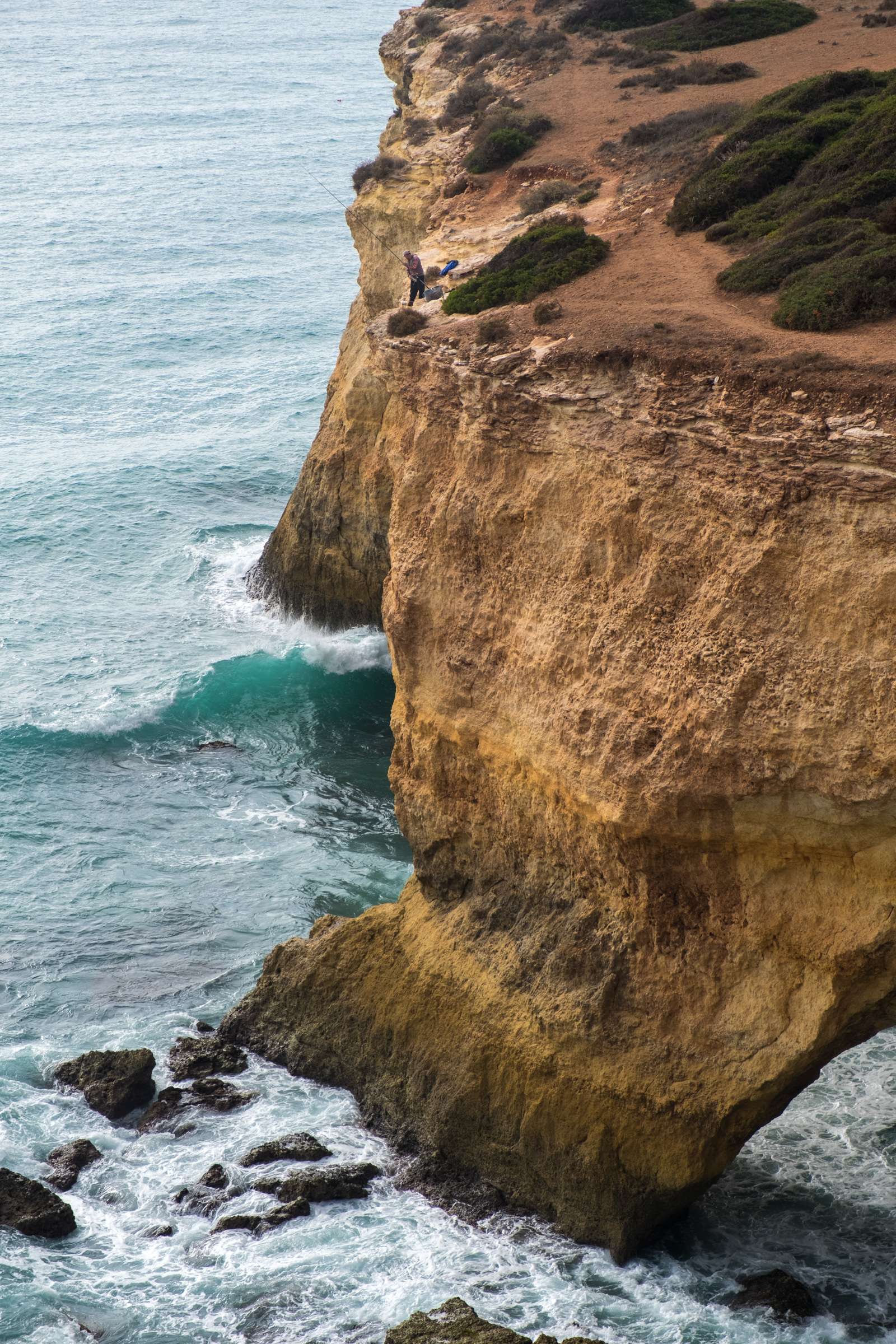 Fisherman fishing from high cliffs on the Algarve