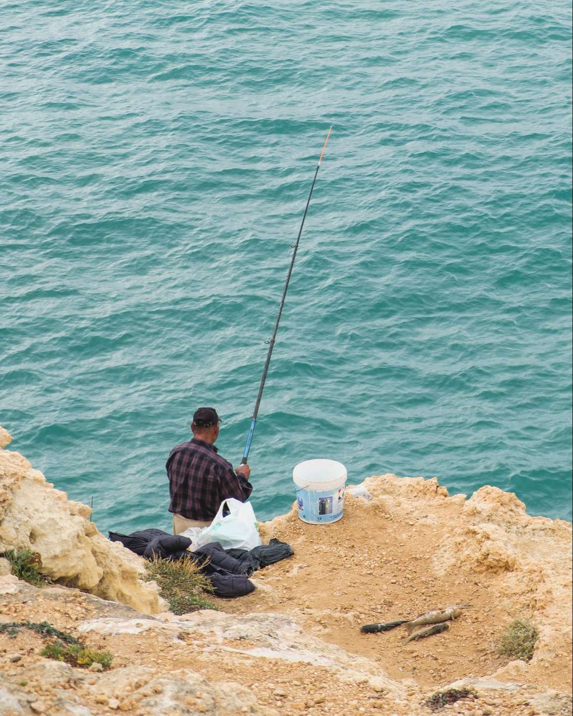 Fisherman fishing on the cliffs of the Algarve