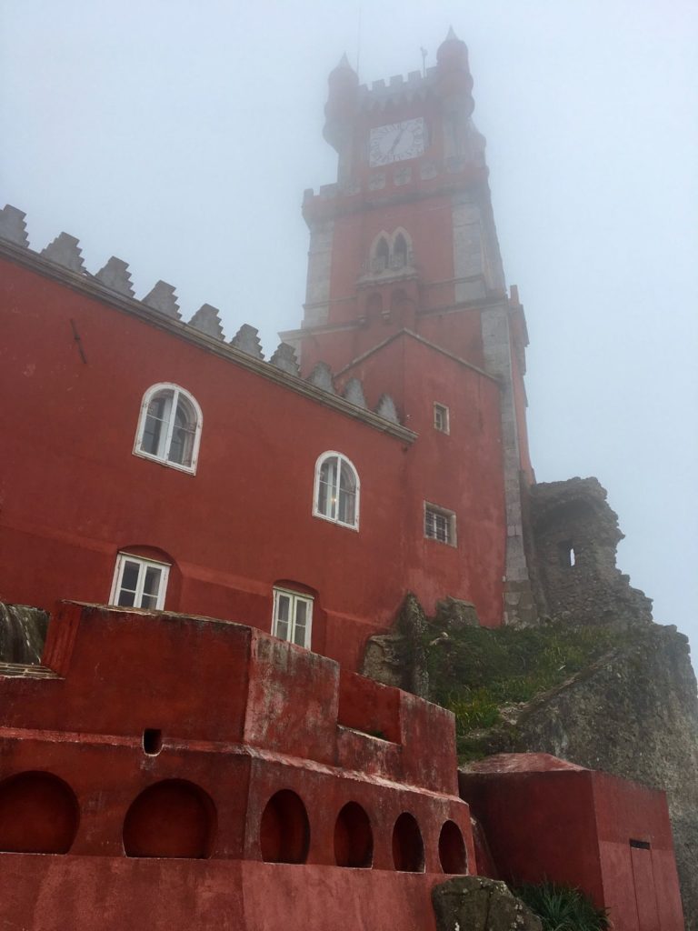 Red tower of Pena palace submerged in thick fog