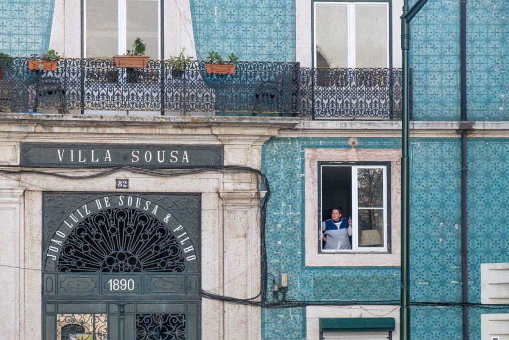 Woman smoking in window of Villa Sousa, Lisbon