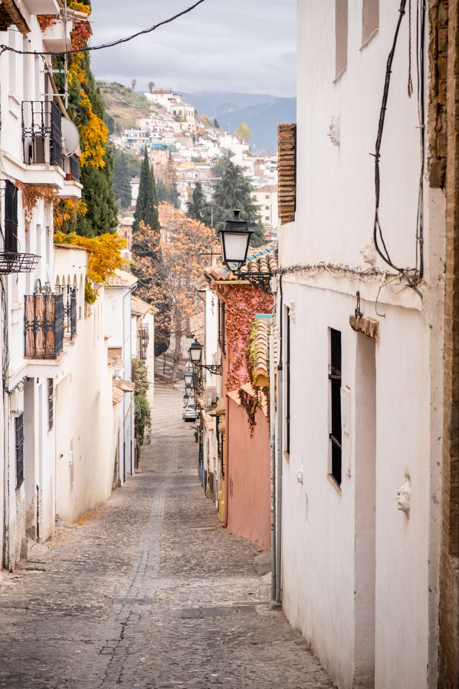 Romantic cobbled street in Granada leading to hilly suburbs