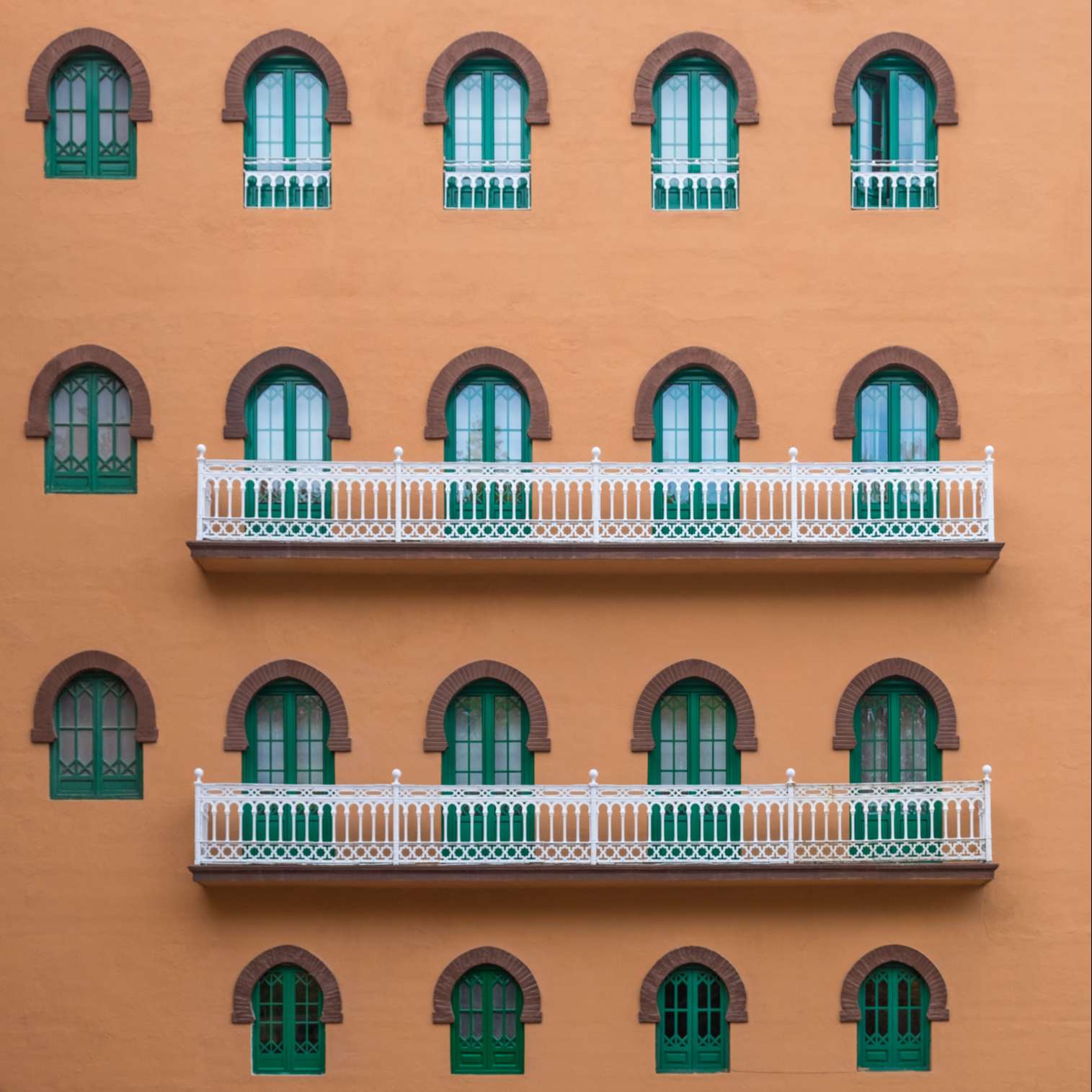 Colourful orange and green facade of the Hotel Alhambra Palace