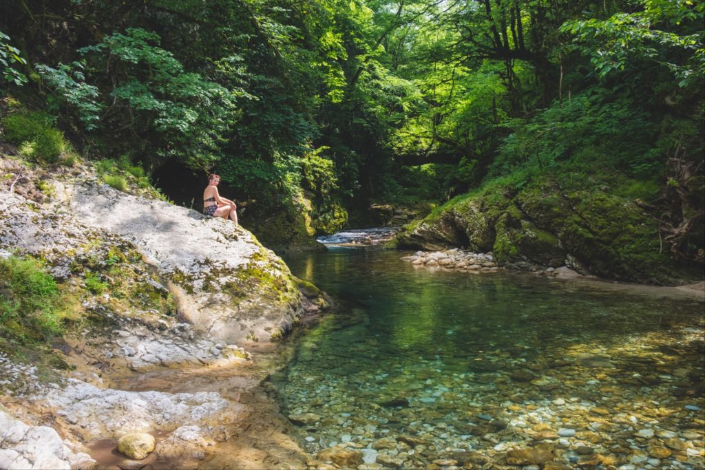 Caroline in Balda canyon with turquoise water and lush green foliage