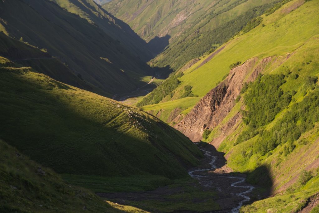 Arghuni gorge near Shatili with light and shadows, flock of sheep on the mountainside