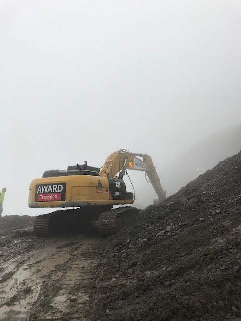 A digger ripping up the road ahead of us on Datvisjvari pass in bad weather