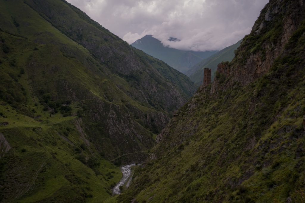 Lone watch tower of Mutso fortress high above the raging river in the valley below