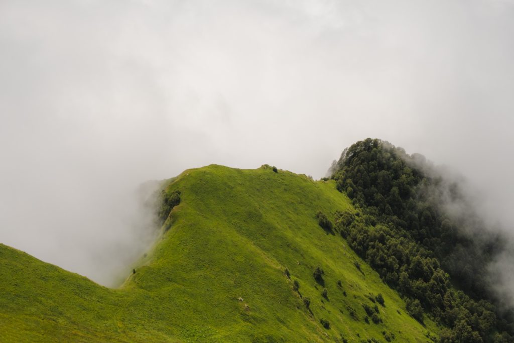 Mountain ridge hiking path and forest protruding through the clouds in Lagodekhi Protected Areas, Georgia