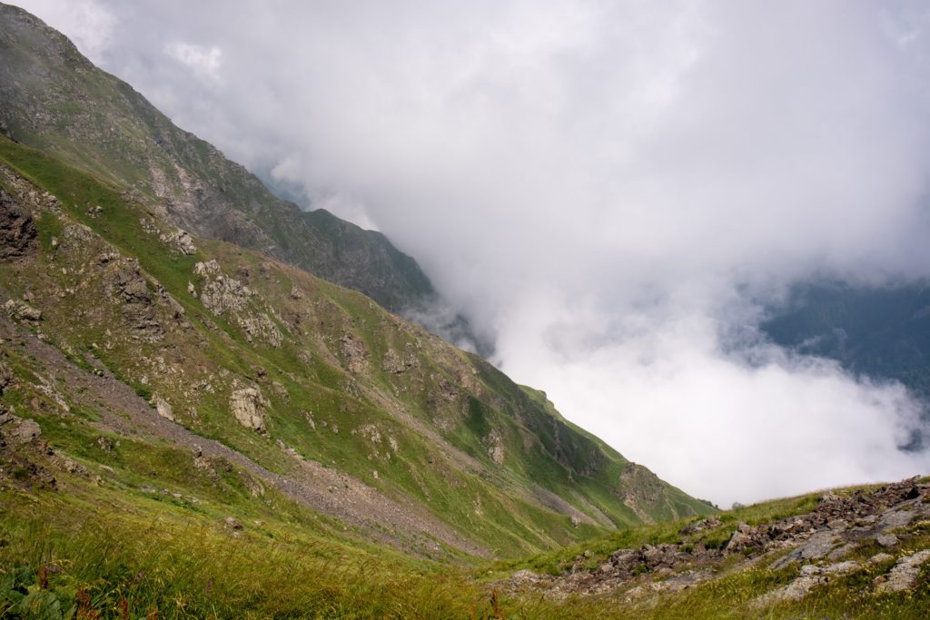 Mountain slope and surrounding landscape high in the Caucasus mountains peeking out above the clouds on a stormy day in Lagodekhi Protected Areas, Georgia