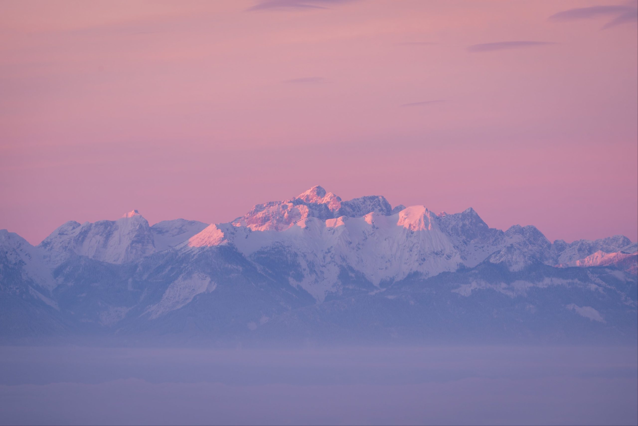Dreamy pink winter sunrise over the Karawanken mountains and the Škrlatica massive in Slovenia from Magdalensberg