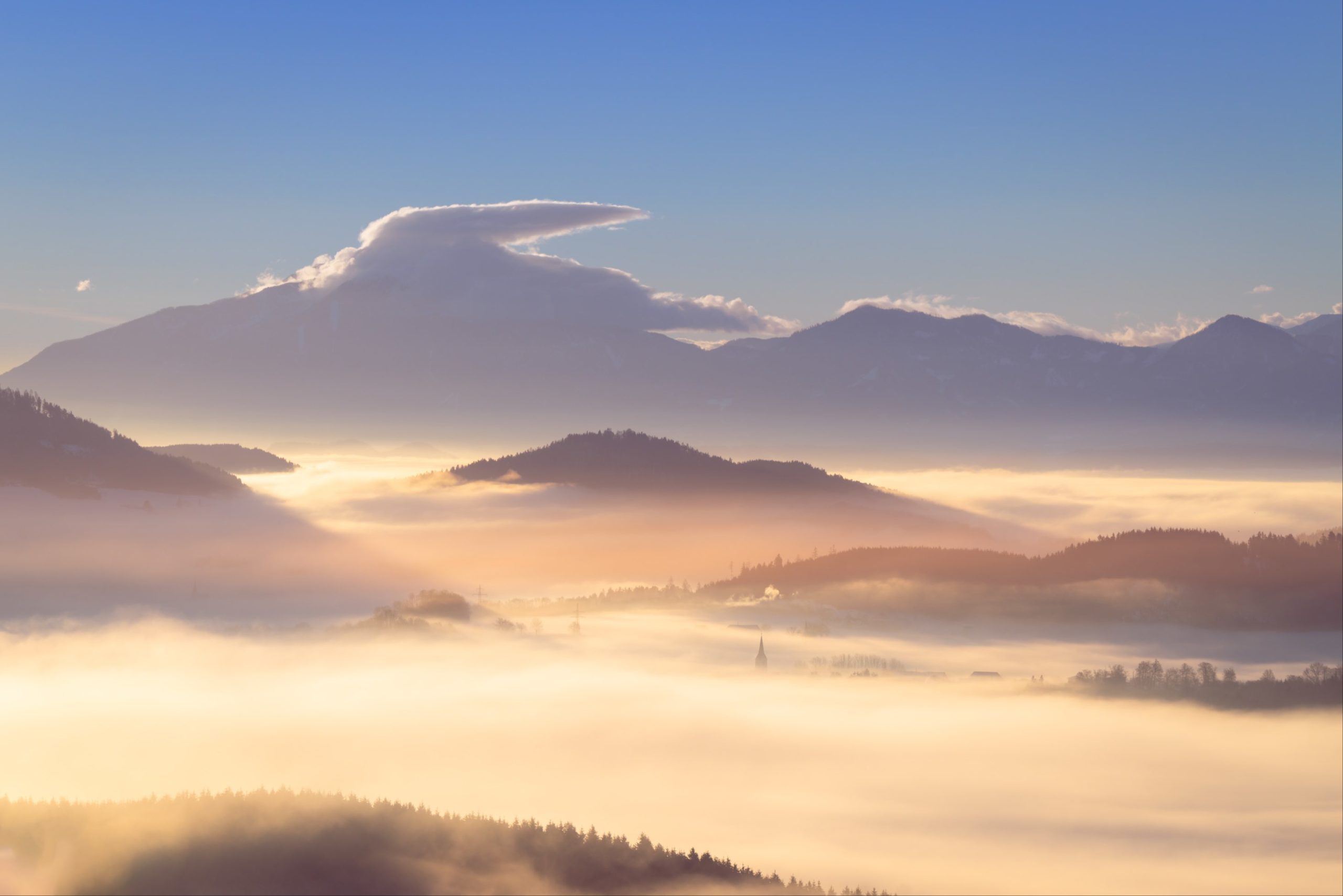 Perfect foggy sunrise over Hörzendorf with church spire poking through, Carinthia, Austria