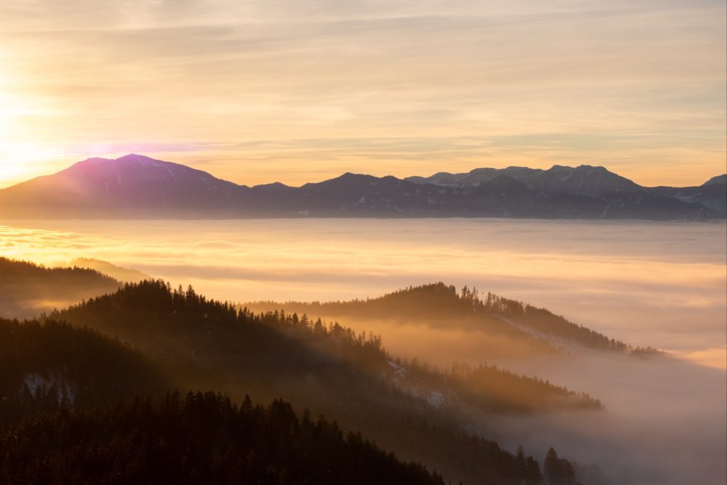 Layers of light and fog, winter sunrise at Magdalensberg with the Karawanken mountains in the background, Carinthia, Austria