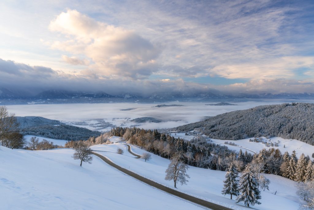 Magical winter sunrise over Magdalensberg with winding mountain road