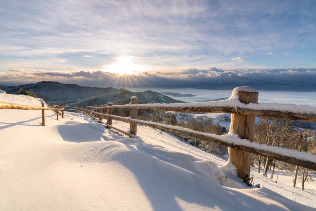 Magical winter sunrise with thick untouched snow covering path on Magdalensberg