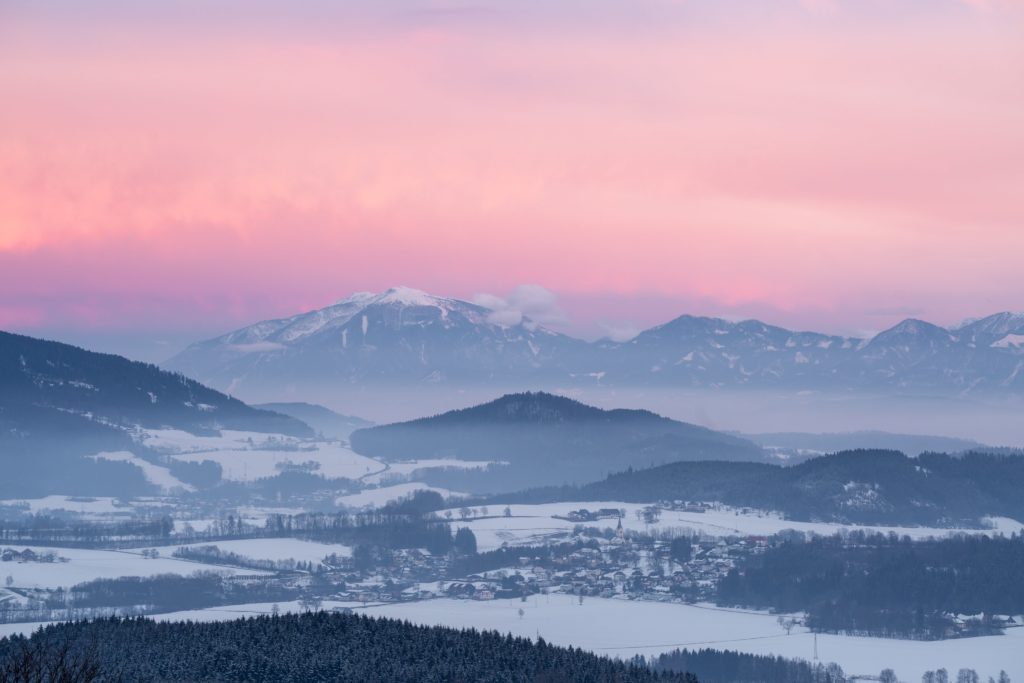Pastel pink sunset over snow covered Hörzendorf, Carinthia, Austria