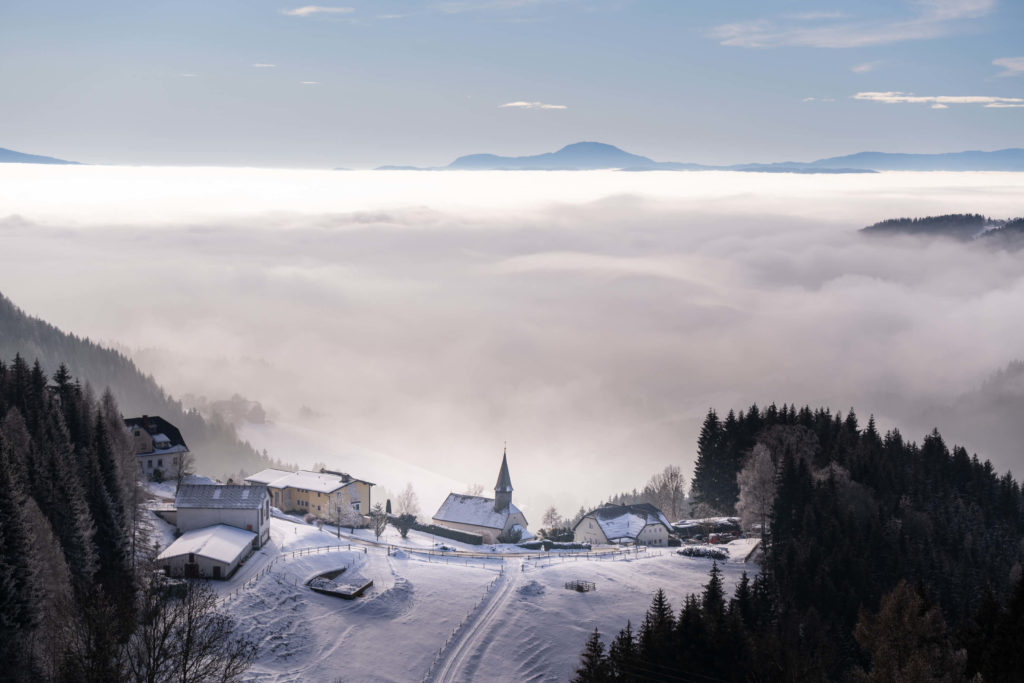 Small church at Preims surrounded by fog and snow, Lavanttal, Carinthia