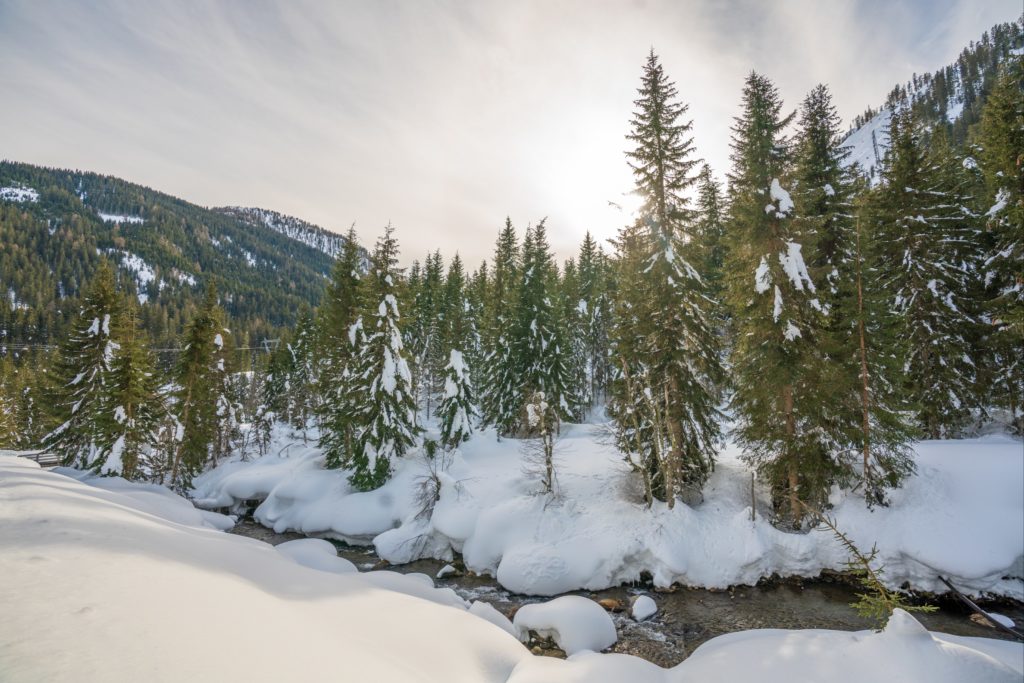 River Gail next to a hiking path in winter surrounded by snow, Obertilliach, Lesachtal