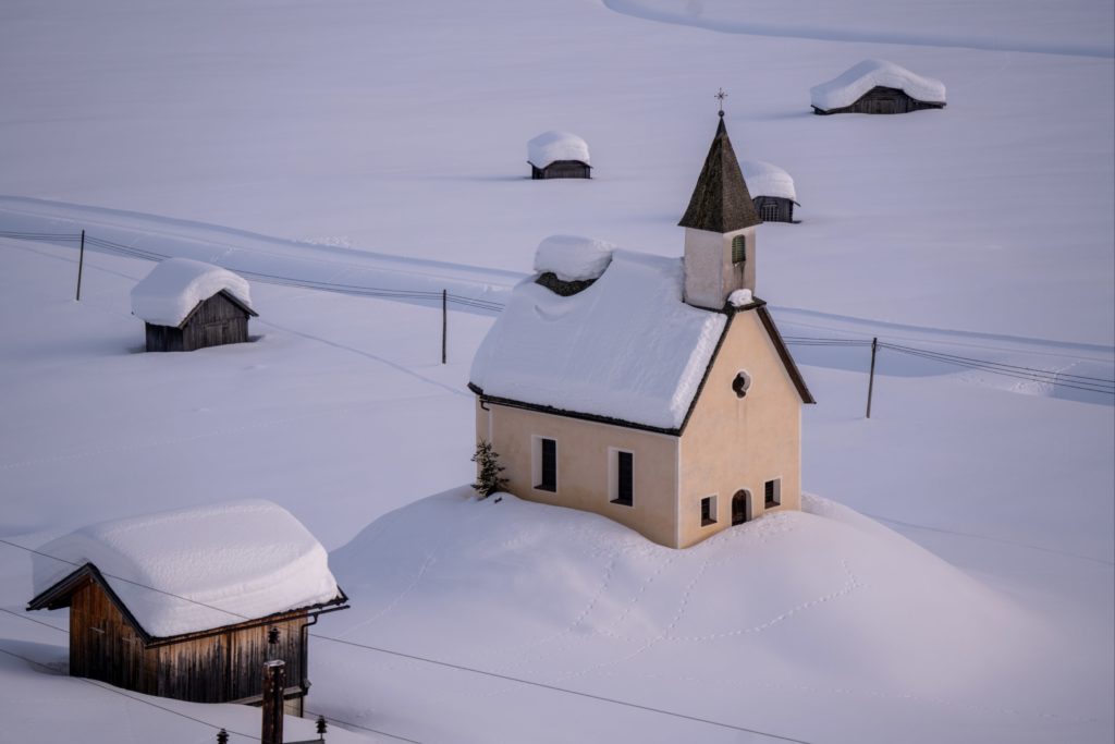 Small cute church covered in thick blanket of snow in the alpine valley of Obertilliach, Lesachtal