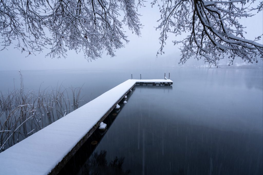 Snow covered boardwalk during a white out at Längsee lake, Carinthia, Austria