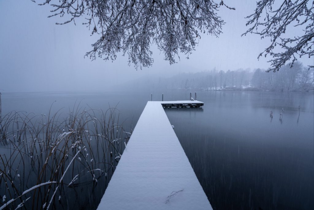 Snow covered boardwalk during a white out at Längsee lake, Carinthia, Austria