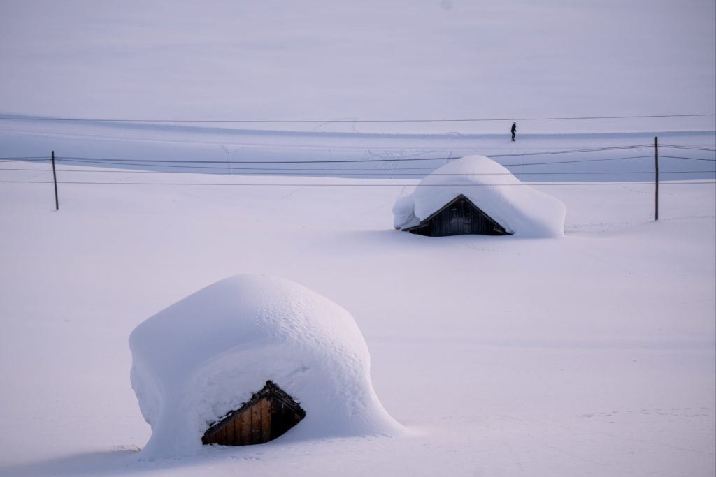 Snow piled on top of wooden huts in winter, Obertilliach, Lesachtal