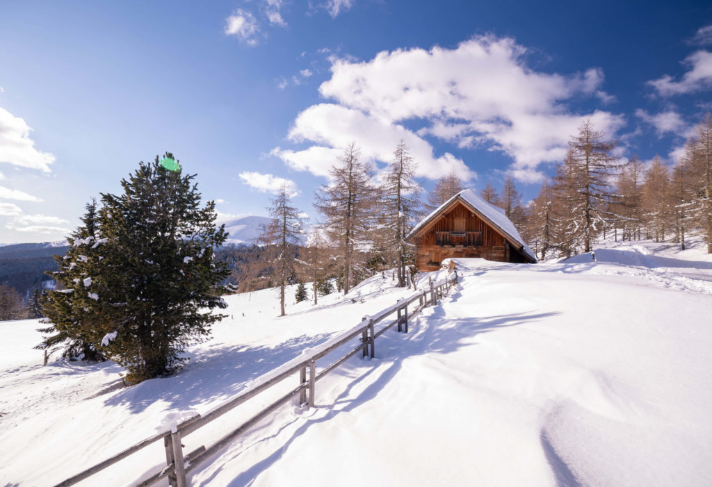 Winter hut covered in snow in the mountains of Hochrindl, Carinthia