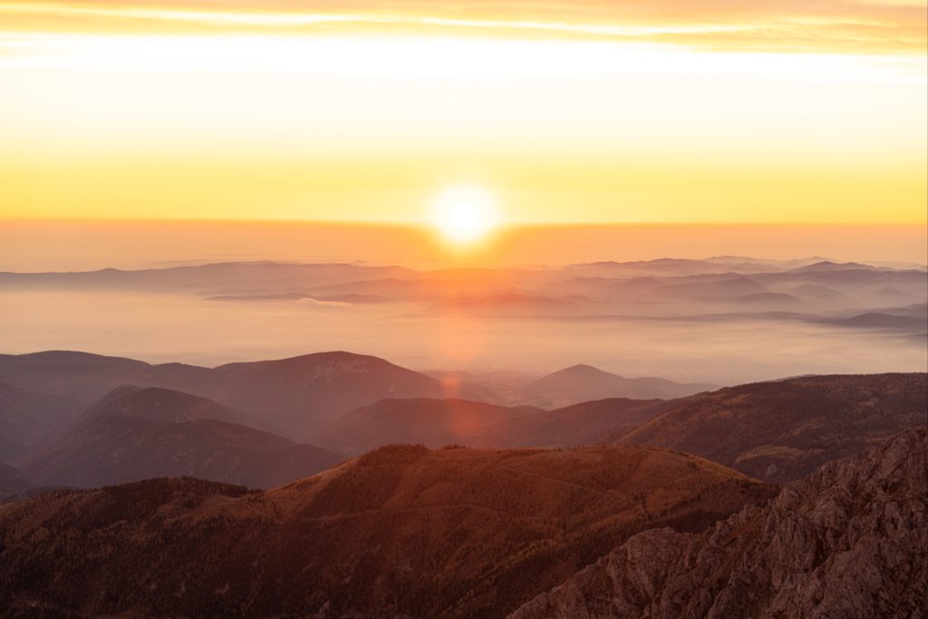 Burning sun rising over the foggy valley from the top of Schneeberg