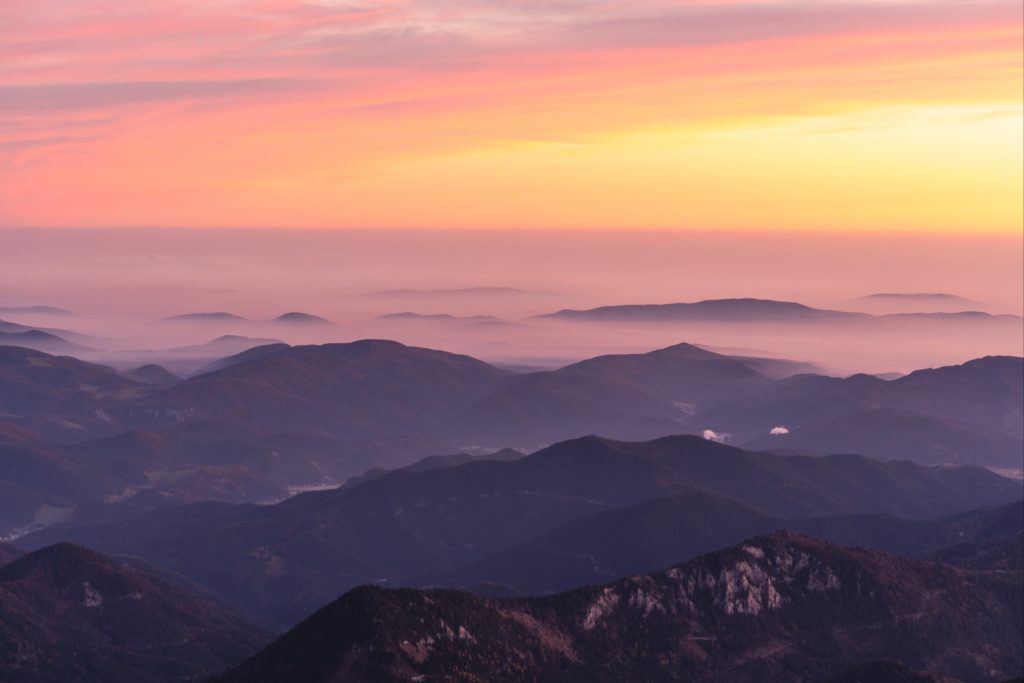 Pastel clouds and fog over the hills from Schneeberg at sunrise